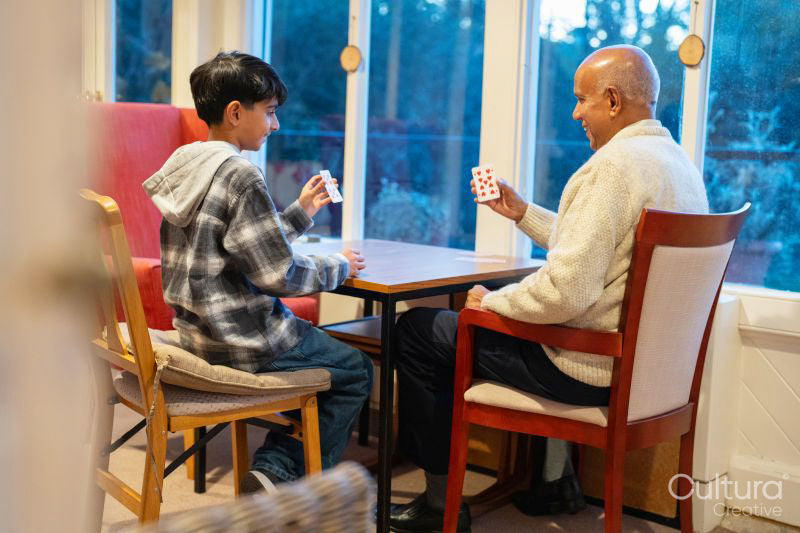 Senior man and grandson playing cards together