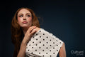 Studio portrait of a woman in a polka dot top with windswept hair