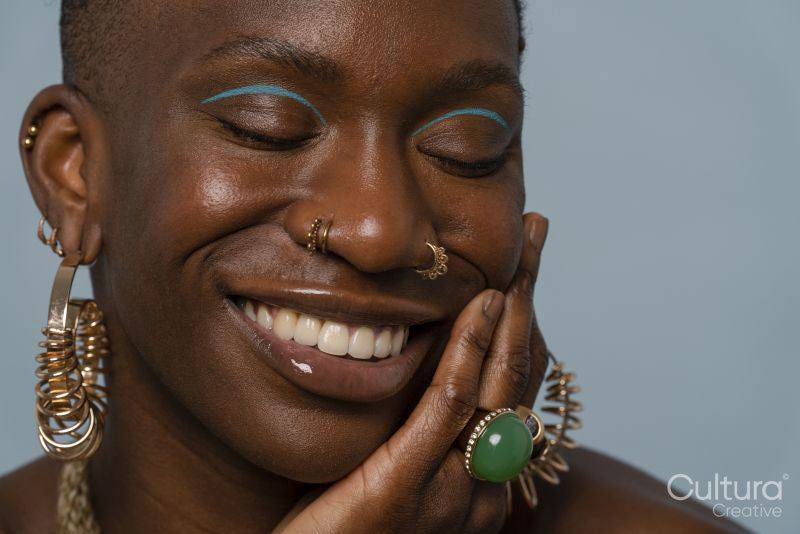 Smiling young woman wearing jewelry and eye make-up