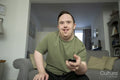 Man sitting on sofa and using remote control