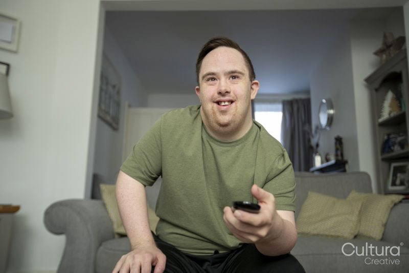 Man sitting on sofa and using remote control