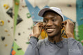 Smiling woman putting on in-ear headphones at gym