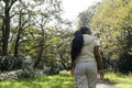 Rear view of woman walking in park on sunny day