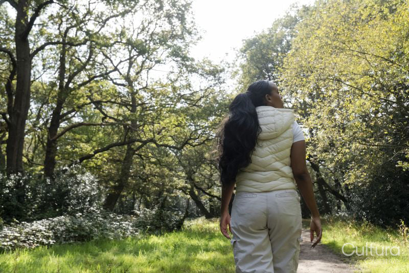 Rear view of woman walking in park on sunny day