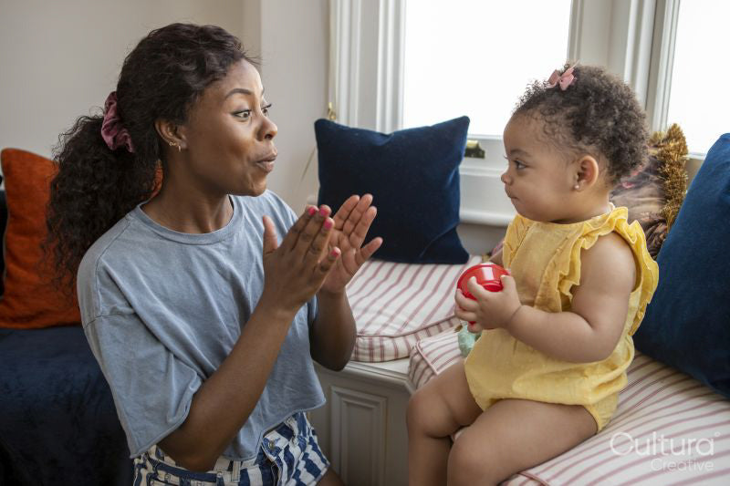 Mother playing with baby daughter at home