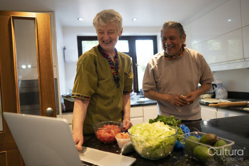 Smiling senior couple looking at laptop in kitchen