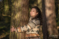 Young woman hugging tree in forest
