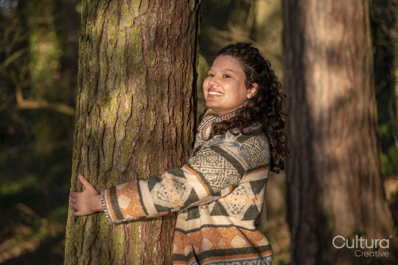 Young woman hugging tree in forest