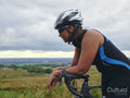 Tired female cyclist resting on bicycle