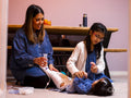 Mother and sister feeding girl through feeding tube