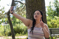 Young woman taking selfie in park