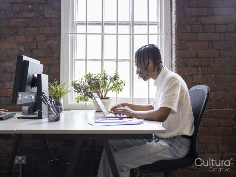 Teenage boy using laptop in office