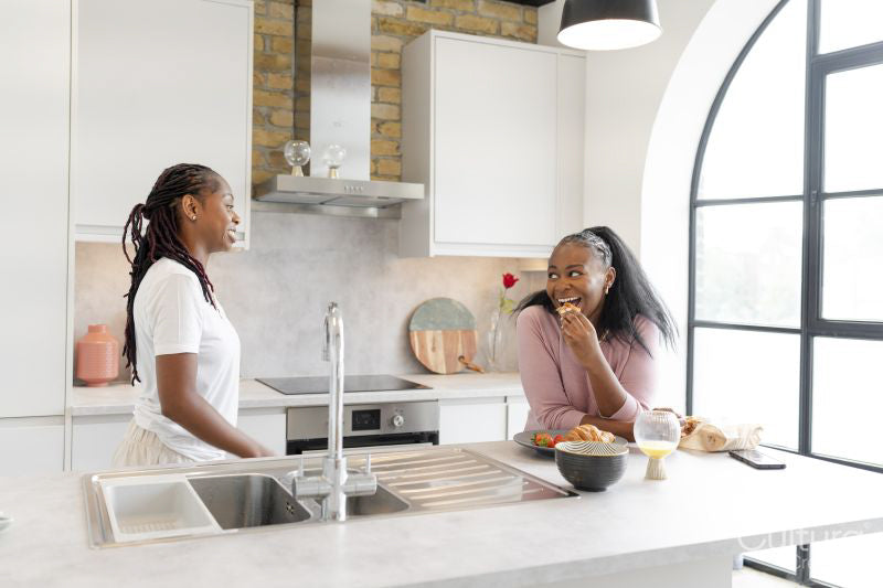 couple chatting and eating in kitchen