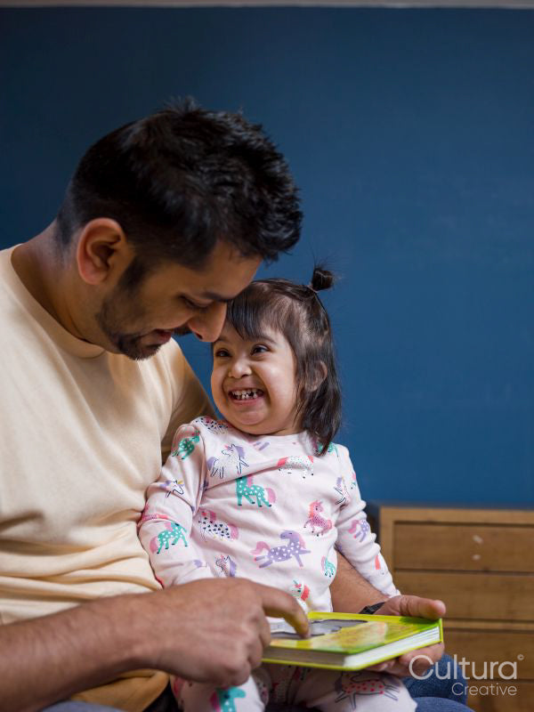 Father reading book to daughter