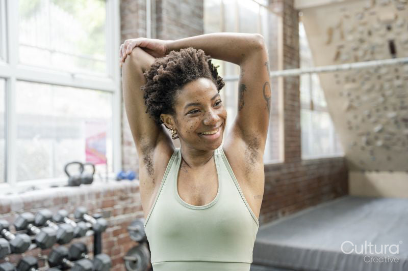 Woman stretching arms in gym before training