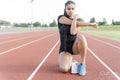 Female athlete stretching before run at stadium
