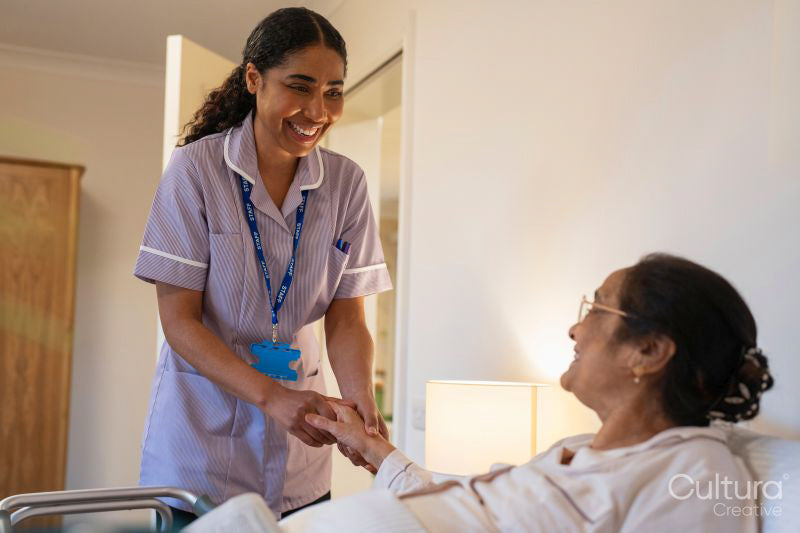 Nurse visiting senior lady in her room at nursing home