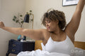 Woman stretching in bed