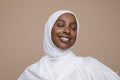 Studio shot of smiling young woman wearing white hijab