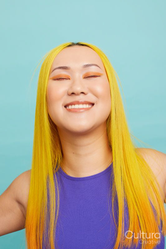 Portrait of smiling woman with long yellow hair and closed eyes