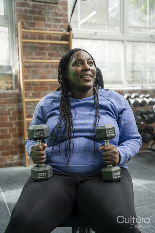 Woman exercising with dumbbells in gym