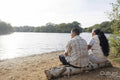 Rear view of couple sitting on lakeshore