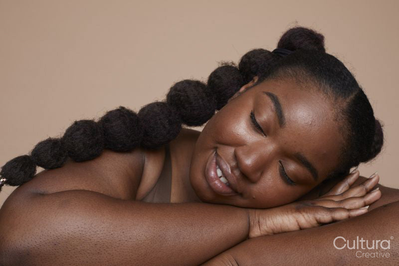 Studio shot of smiling young woman with braided hair
