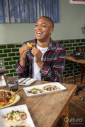 Smiling man enjoying Me,ican food at restaurant table