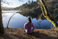 Young woman meditating at lake