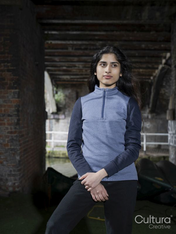 Young brunette woman standing below bridge near canal