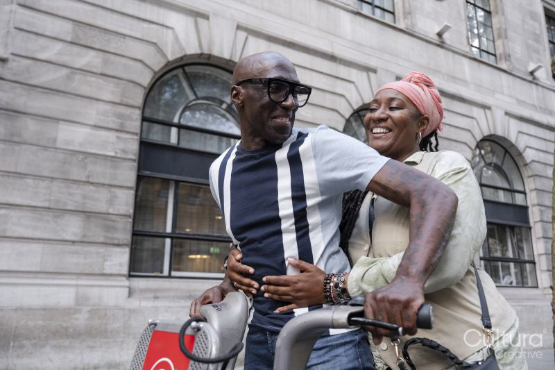 Mature couple using city bike on street