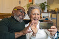 Senior couple using smart phone at home