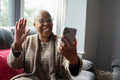 Mature woman sitting in living room with her smart phone