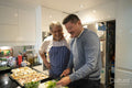Smiling father and adult son cooking together