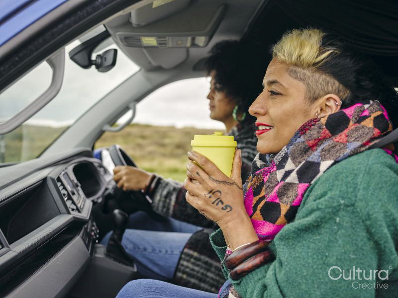 Woman holding cup in car