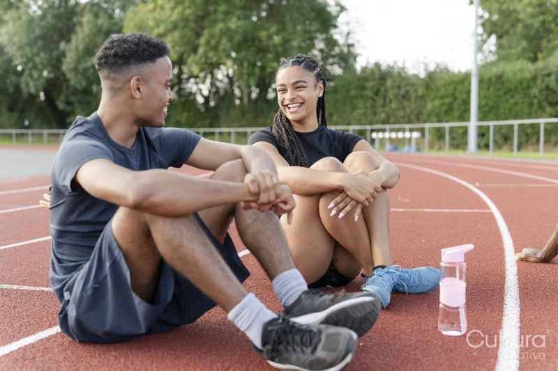 Couple of athletes resting at sports track after training