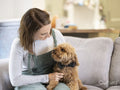 Woman sitting on sofa with dog