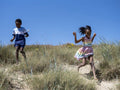 Siblings running on beach