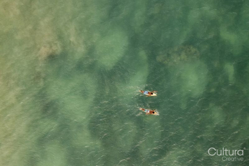Indonesia, Lombok, Aerial view of men surfing in sea