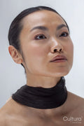Studio portrait of woman with hair wrapped around neck