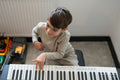 Boy playing music keyboard at home