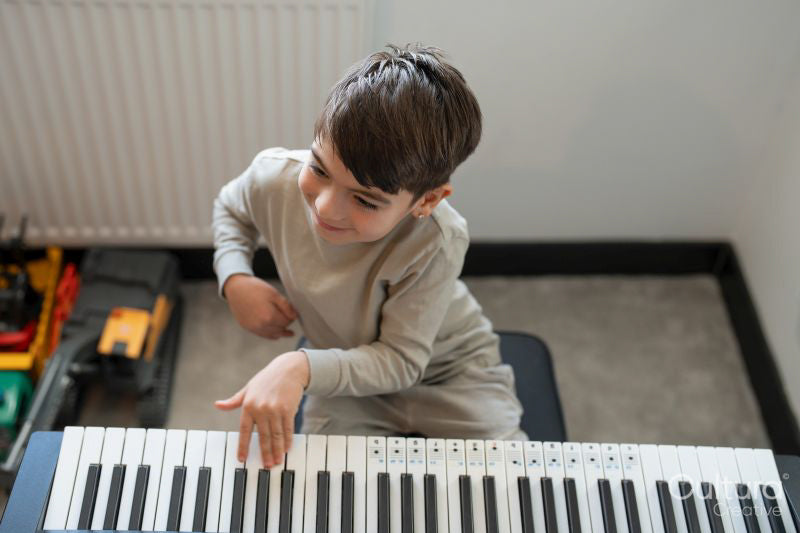 Boy playing music keyboard at home