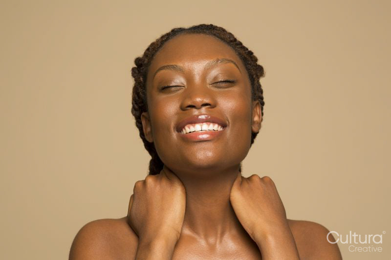 Portrait of smiling woman touching neck