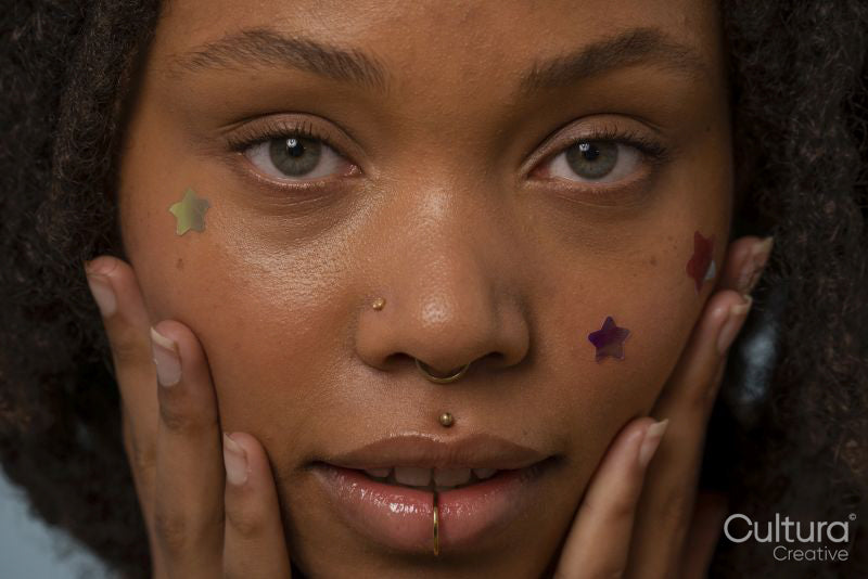Portrait of young woman wearing star stickers on face