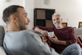 Smiling male couple relaxing on sofa at home