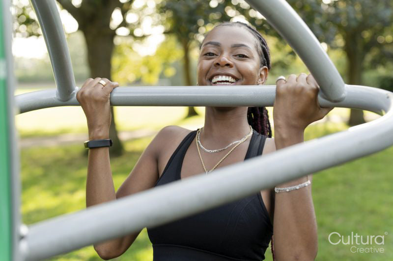 Smiling young woman exercising in outdoor gym