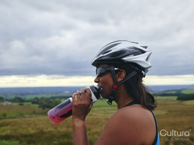 Female cyclist drinking from water bottle