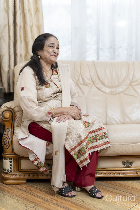 Cheerful senior woman sitting on sofa in living room