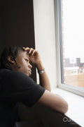 Teenage boy looking through window at home