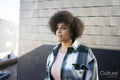 Woman in plaid shirt standing outdoors